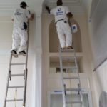 Two painters interior painting high ceiling
