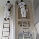 Two painters interior painting high ceiling