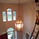 Interior painting on ladder, high ceiling entryway